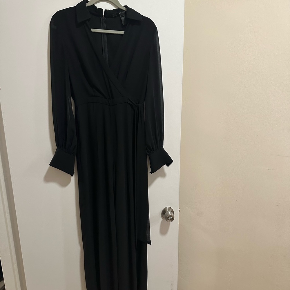 Elegant black jumpsuit. Sheer sleeves and button cuffs